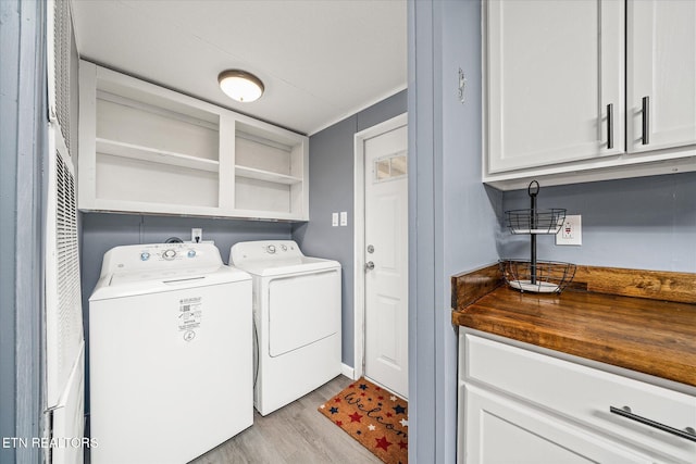 clothes washing area with separate washer and dryer, ornamental molding, cabinets, and light wood-type flooring