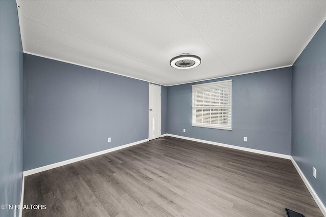 empty room with hardwood / wood-style floors and a textured ceiling