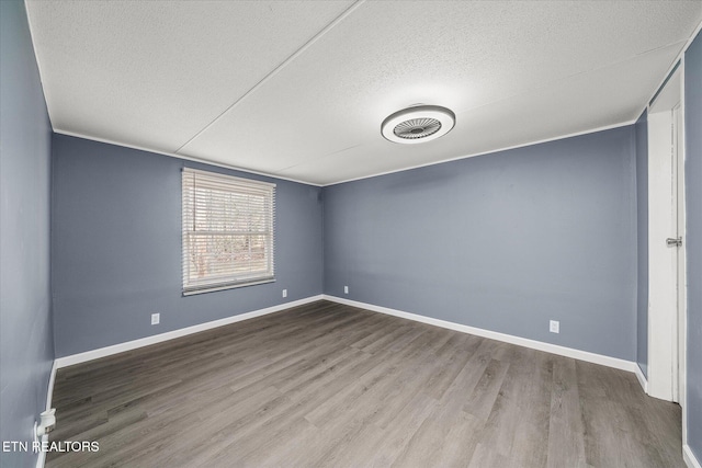 spare room featuring hardwood / wood-style floors, a textured ceiling, and crown molding