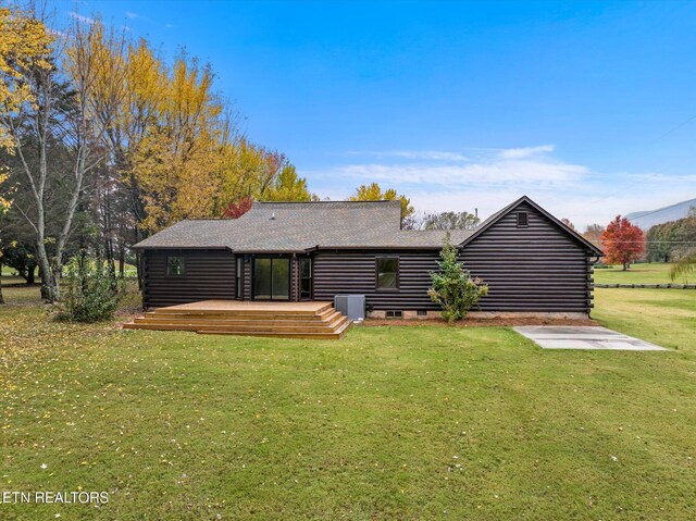 rear view of property featuring a deck and a lawn