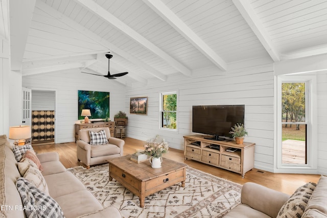 living room featuring wood walls, plenty of natural light, ceiling fan, and light hardwood / wood-style flooring