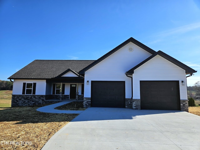 view of front of home featuring roof with shingles, concrete driveway, and an attached garage