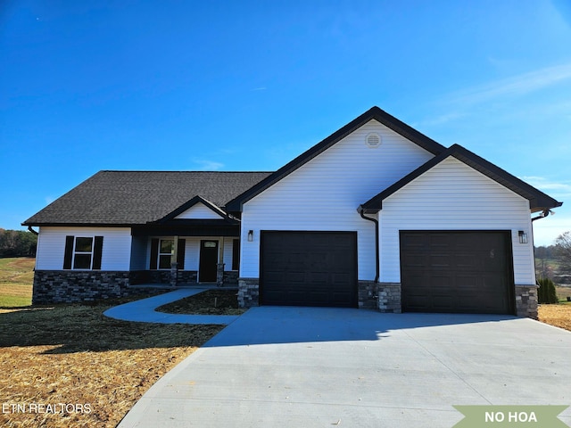 view of front of house with roof with shingles, concrete driveway, and an attached garage