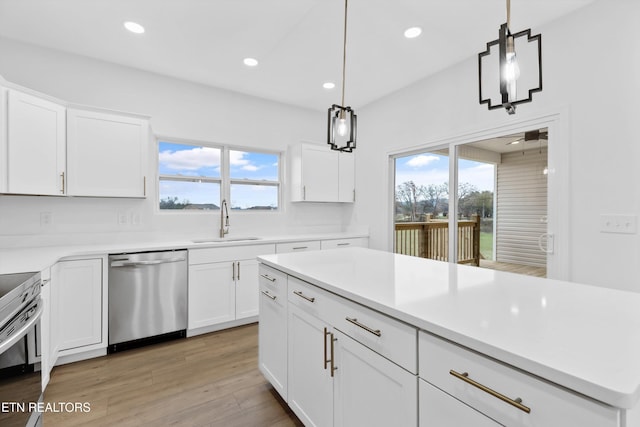 kitchen featuring white cabinets, appliances with stainless steel finishes, a wealth of natural light, and sink