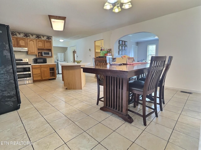 dining space featuring washer / dryer and light tile patterned floors