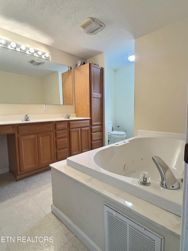 bathroom featuring vanity, a textured ceiling, toilet, and a tub