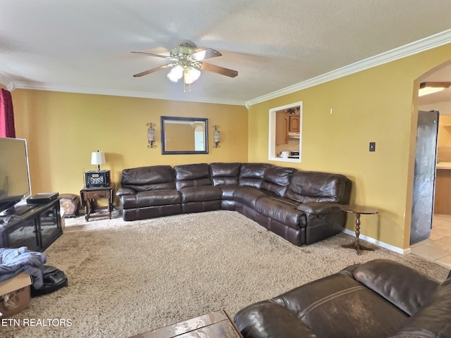 living room with tile patterned flooring, a textured ceiling, ceiling fan, and crown molding