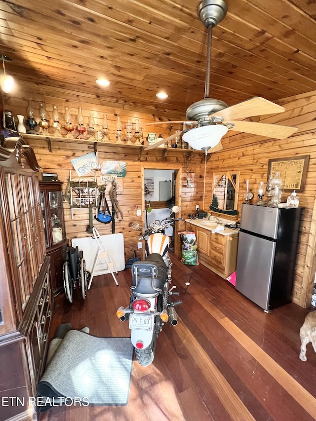 kitchen with hardwood / wood-style flooring, stainless steel fridge, wooden ceiling, and wooden walls