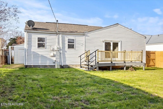 back of property featuring a wooden deck and a lawn