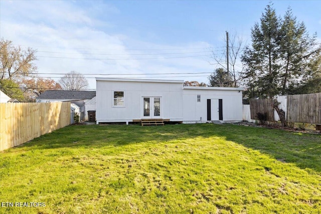 rear view of house featuring french doors and a yard