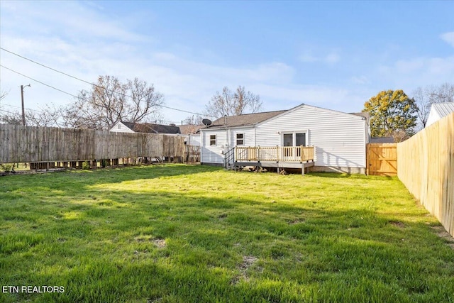 rear view of property featuring a yard and a deck