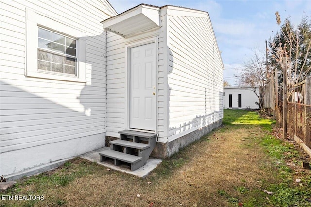 entrance to property featuring a lawn