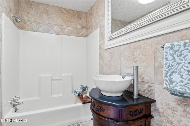 bathroom featuring tile walls, shower / bathtub combination, and a textured ceiling