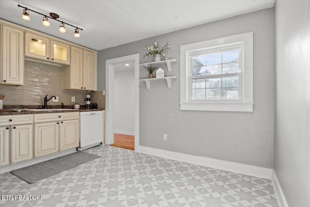 kitchen featuring dishwasher, decorative backsplash, sink, and cream cabinets