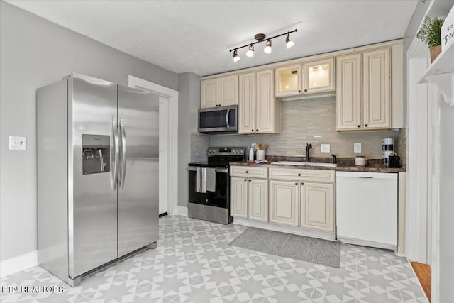 kitchen featuring decorative backsplash, cream cabinets, sink, and appliances with stainless steel finishes