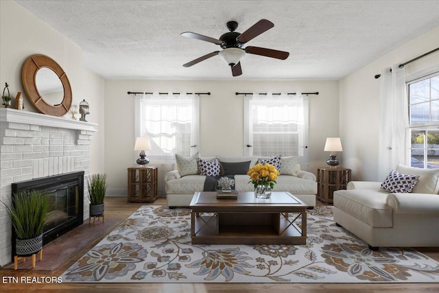 living room featuring a fireplace, a wealth of natural light, hardwood / wood-style floors, and ceiling fan