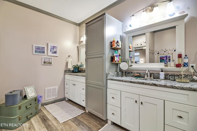 bathroom featuring crown molding, hardwood / wood-style floors, and vanity