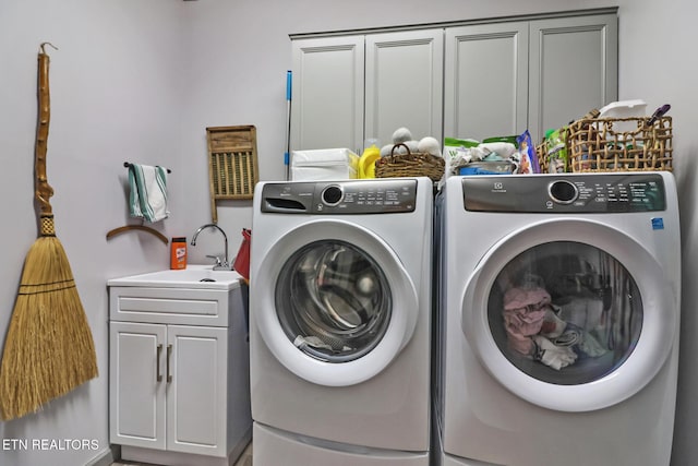 washroom with washing machine and dryer, sink, and cabinets