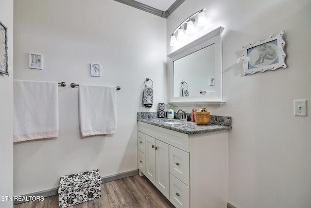 bathroom featuring hardwood / wood-style flooring, vanity, and ornamental molding