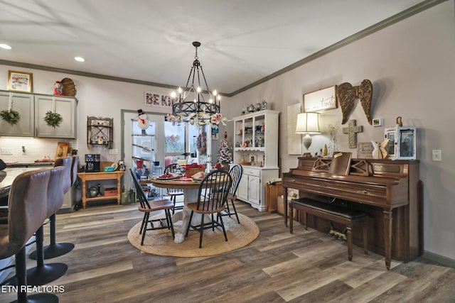 dining space featuring dark hardwood / wood-style floors, an inviting chandelier, and crown molding