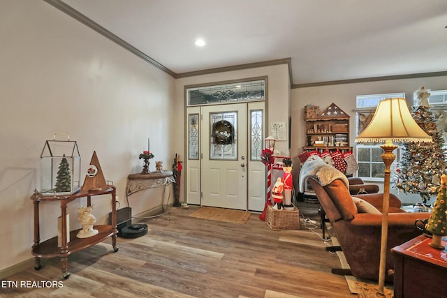 entryway with wood-type flooring and crown molding