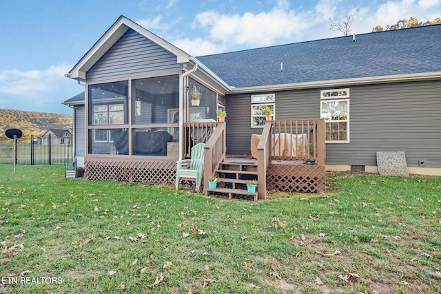 rear view of house with a sunroom and a lawn