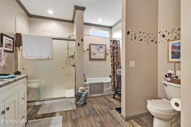 full bathroom featuring hardwood / wood-style floors, separate shower and tub, vanity, ornamental molding, and toilet