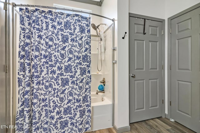 bathroom featuring wood-type flooring and shower / bathtub combination with curtain