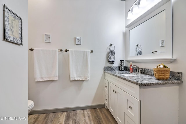 bathroom with vanity, hardwood / wood-style flooring, and toilet