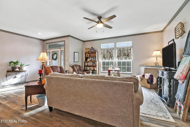 living room with hardwood / wood-style flooring, crown molding, and ceiling fan