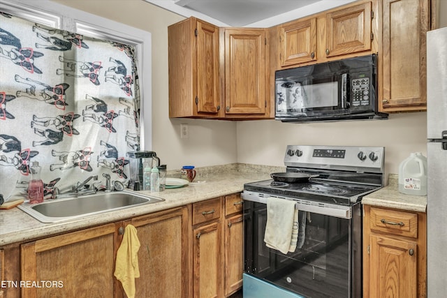 kitchen with electric range, white fridge, and sink