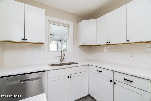 kitchen with tasteful backsplash, stainless steel dishwasher, sink, hardwood / wood-style floors, and white cabinetry