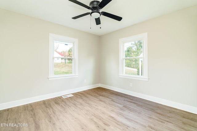 empty room featuring light hardwood / wood-style floors, a wealth of natural light, and ceiling fan