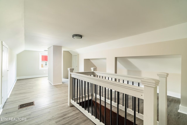 corridor featuring wood-type flooring and lofted ceiling