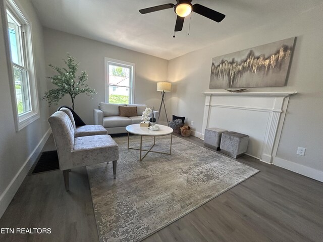 living room with visible vents, baseboards, a ceiling fan, and wood finished floors
