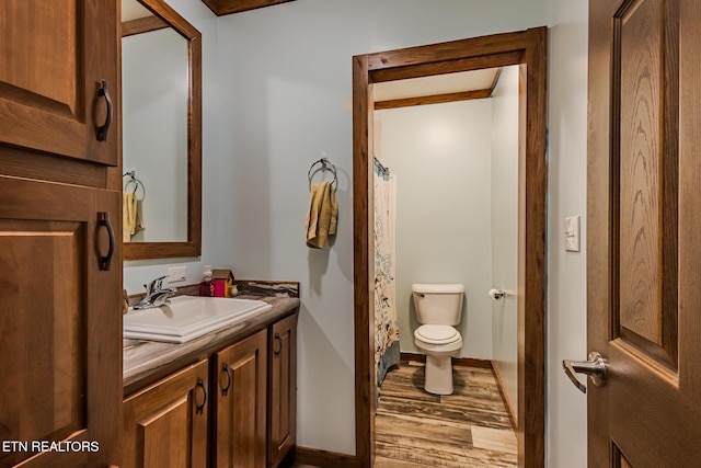 bathroom featuring hardwood / wood-style floors, vanity, curtained shower, and toilet