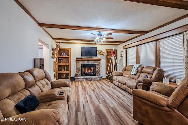 living room featuring beam ceiling, ceiling fan, hardwood / wood-style floors, and a textured ceiling