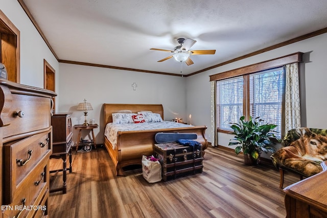 bedroom featuring a textured ceiling, ceiling fan, dark hardwood / wood-style floors, and ornamental molding