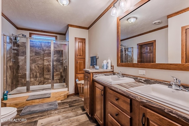 bathroom featuring wood-type flooring, an enclosed shower, a textured ceiling, vanity, and ornamental molding