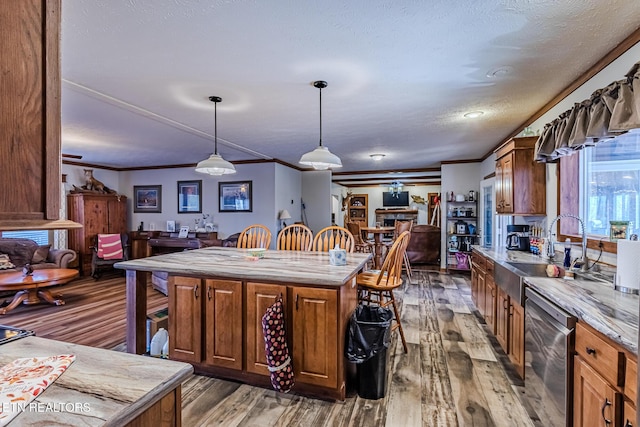 kitchen with hanging light fixtures, dark hardwood / wood-style flooring, stainless steel dishwasher, crown molding, and a kitchen island