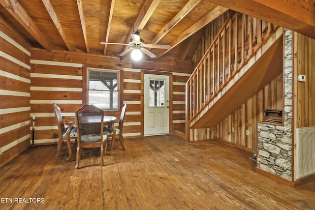 unfurnished dining area with ceiling fan, hardwood / wood-style floors, wooden walls, and wooden ceiling