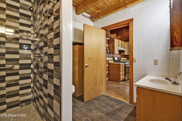 bathroom featuring toilet, vanity, tile walls, beam ceiling, and wooden ceiling