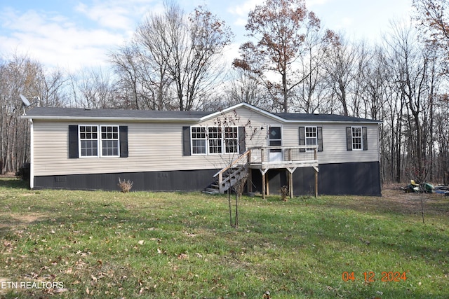 view of front of house with a deck and a front lawn