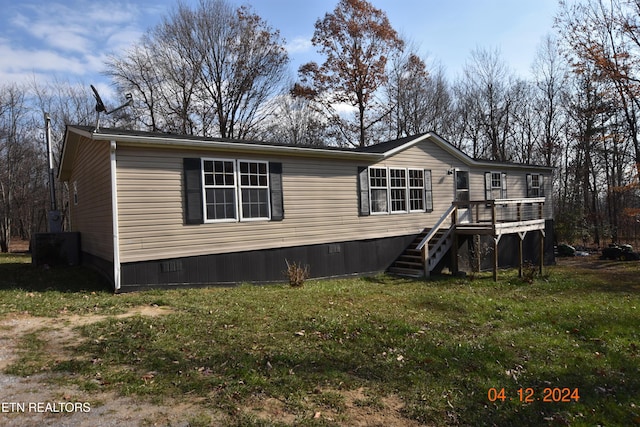 view of front of home featuring a front lawn and a deck