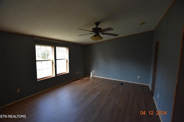 unfurnished room featuring a textured ceiling, ceiling fan, and dark wood-type flooring