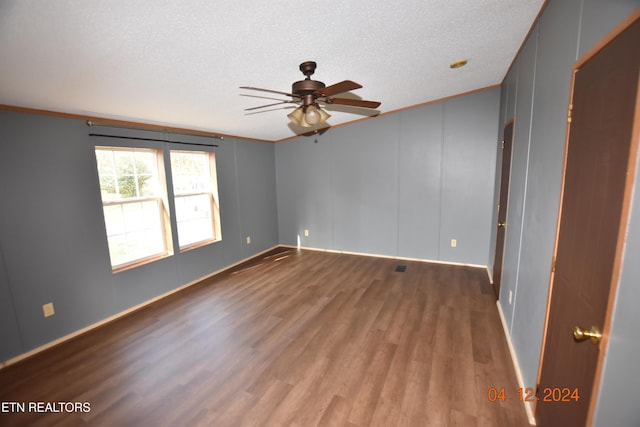 unfurnished room featuring a textured ceiling, dark hardwood / wood-style floors, ceiling fan, and ornamental molding