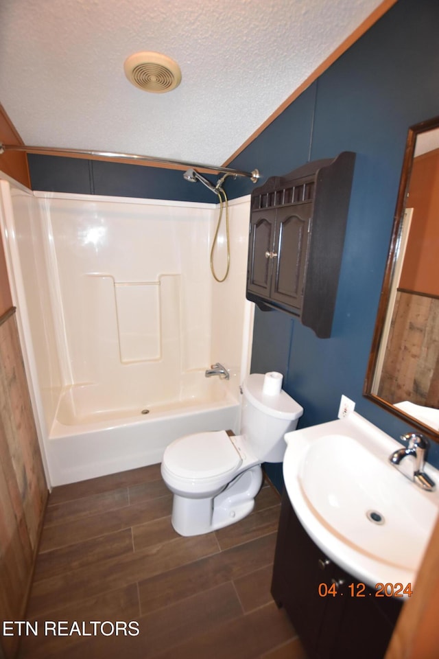 full bathroom featuring tub / shower combination, hardwood / wood-style floors, a textured ceiling, toilet, and vanity