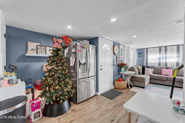 kitchen featuring stainless steel fridge and light hardwood / wood-style flooring