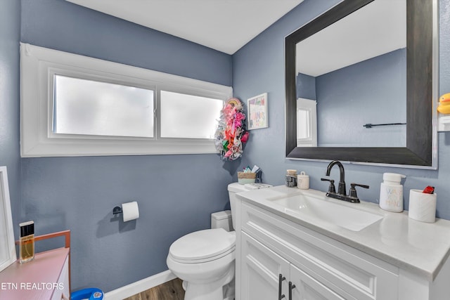 bathroom with hardwood / wood-style floors, vanity, and toilet