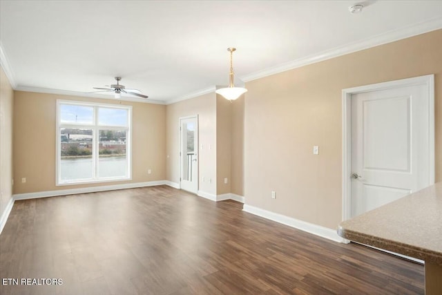 empty room featuring ceiling fan, ornamental molding, and dark wood-type flooring